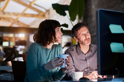 Two people looking at a computer